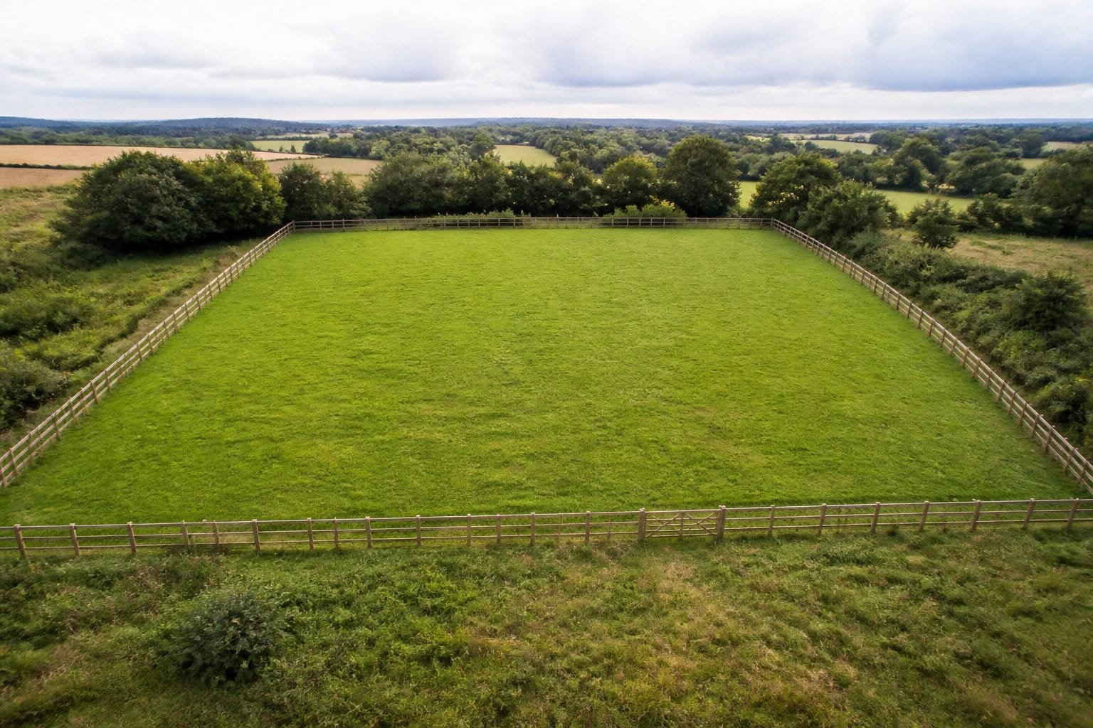 Pré carré entouré d'une clôture équestre en bois, vu du ciel